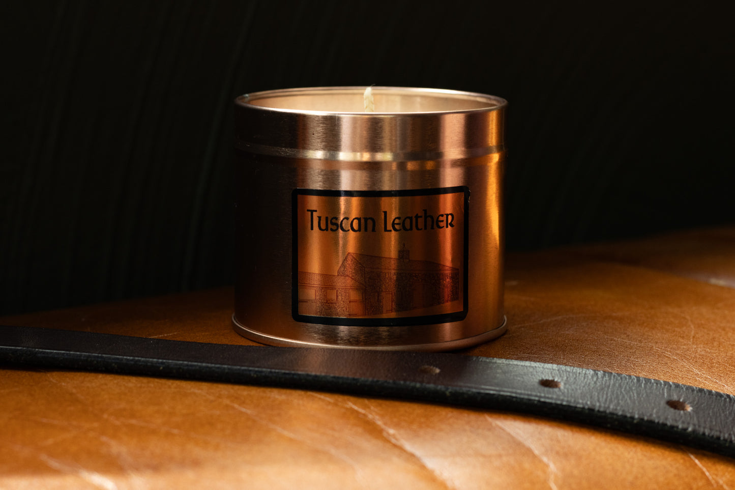 Irish Soy Wax Candle in a Copper container with 'Tuscan Leather' label on a leather surface