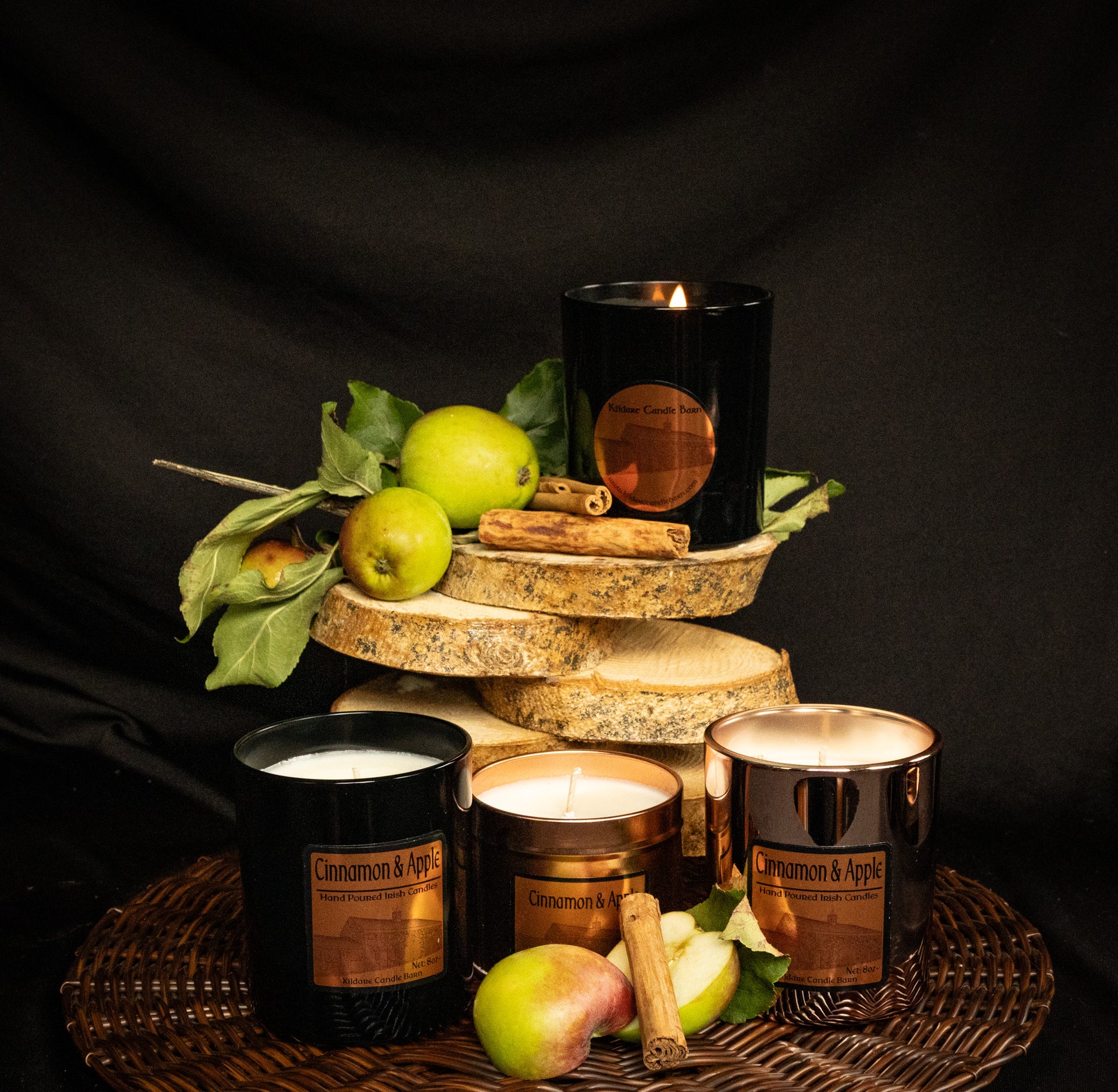Irish Soy Wax Candles in a copper tin and black & copper jars with green apples and cinnamon sticks on a dark background