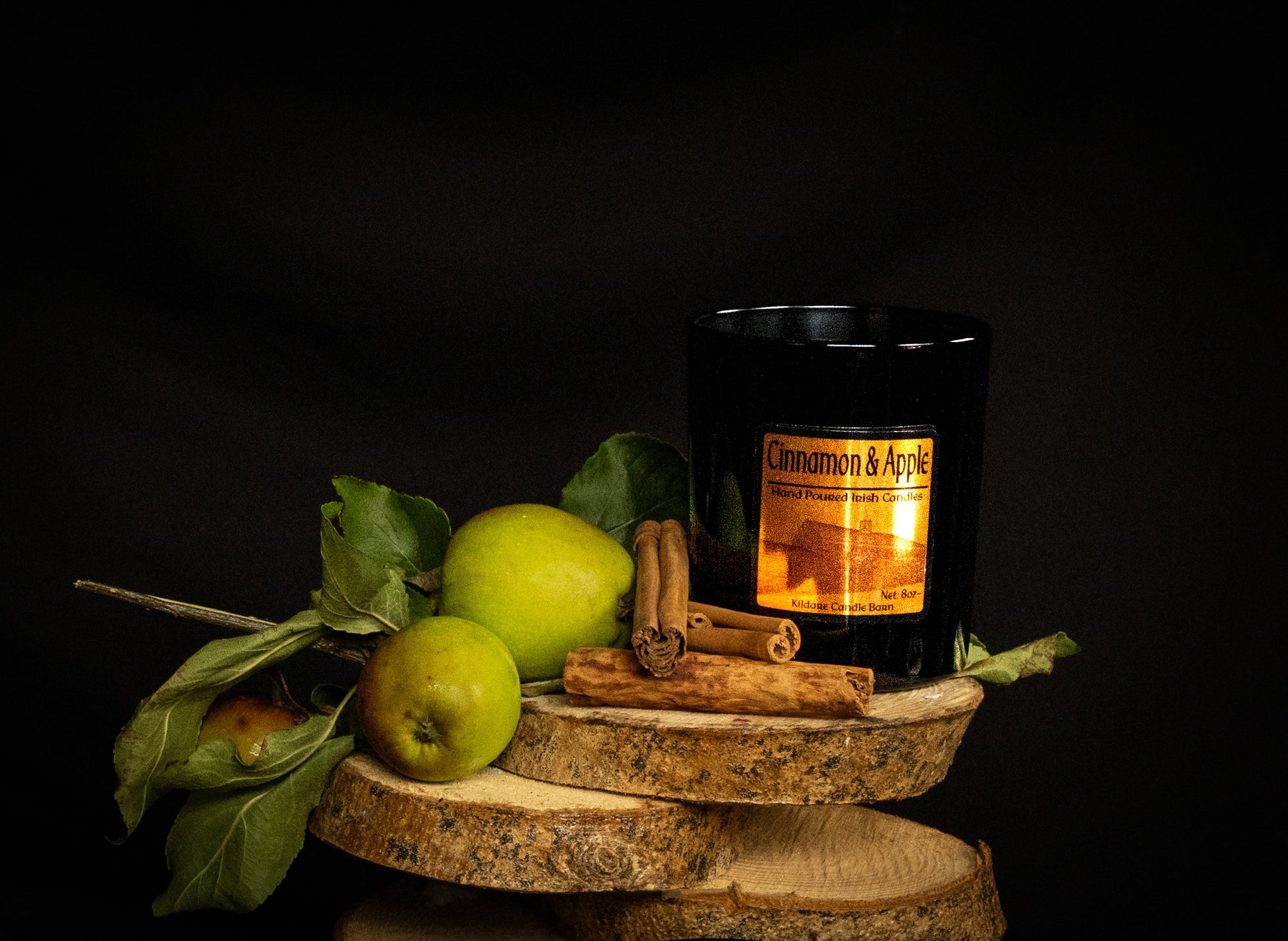 Soy Wax Candle labeled 'Cinnamon & Apple' with apples and cinnamon sticks on a dark background