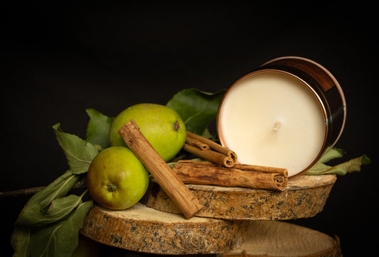 Irish Soy Wax Candle in a copper tin with green apples and cinnamon sticks on a dark background