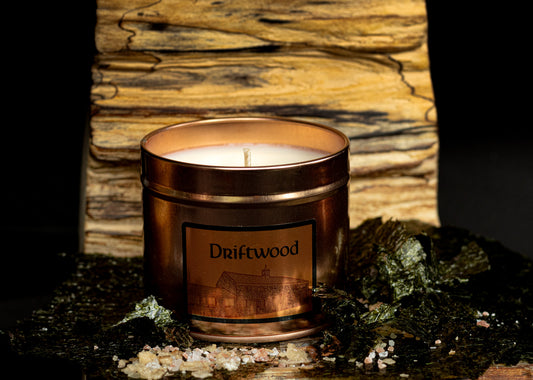 Irish Soy Wax Candle in a 'Driftwood' scented tin with a driftwood background and rock salt and seaweed.