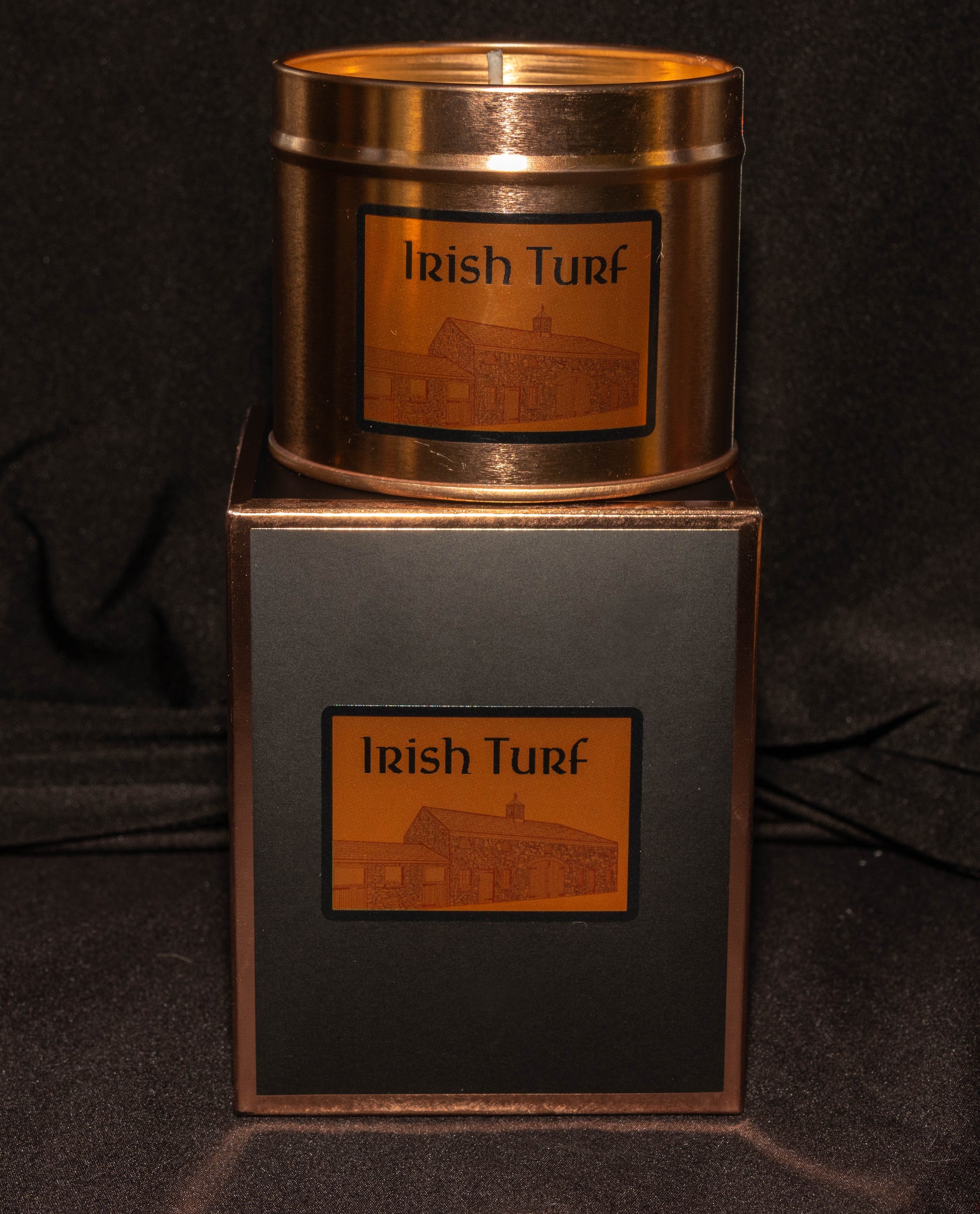 Irish Soy Wax Candle in  copper tin  with 'Irish Turf' branding on a gift box on a dark background