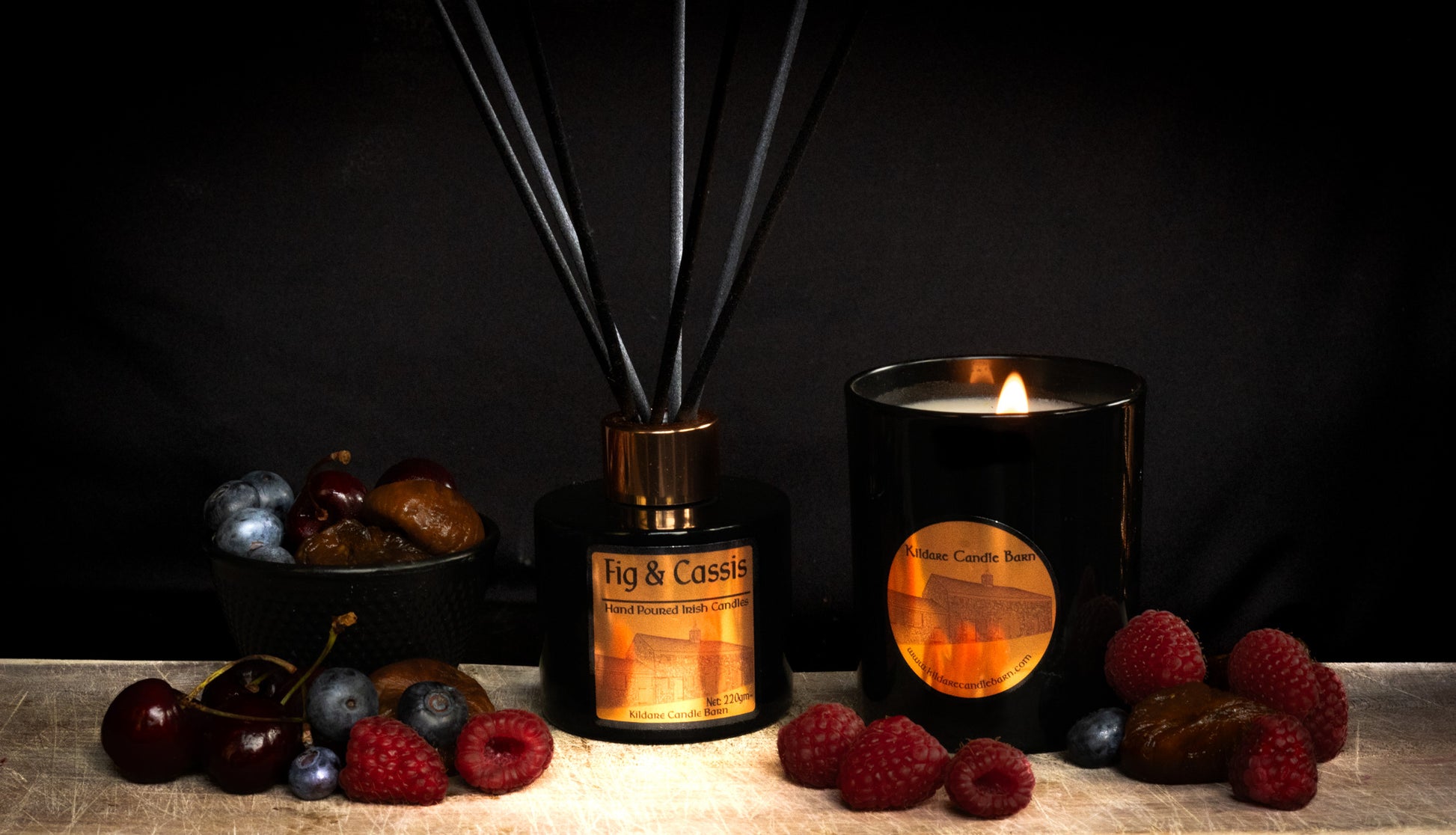 Fig & Cassis Fragrance diffuser and candle with berries on a dark background
