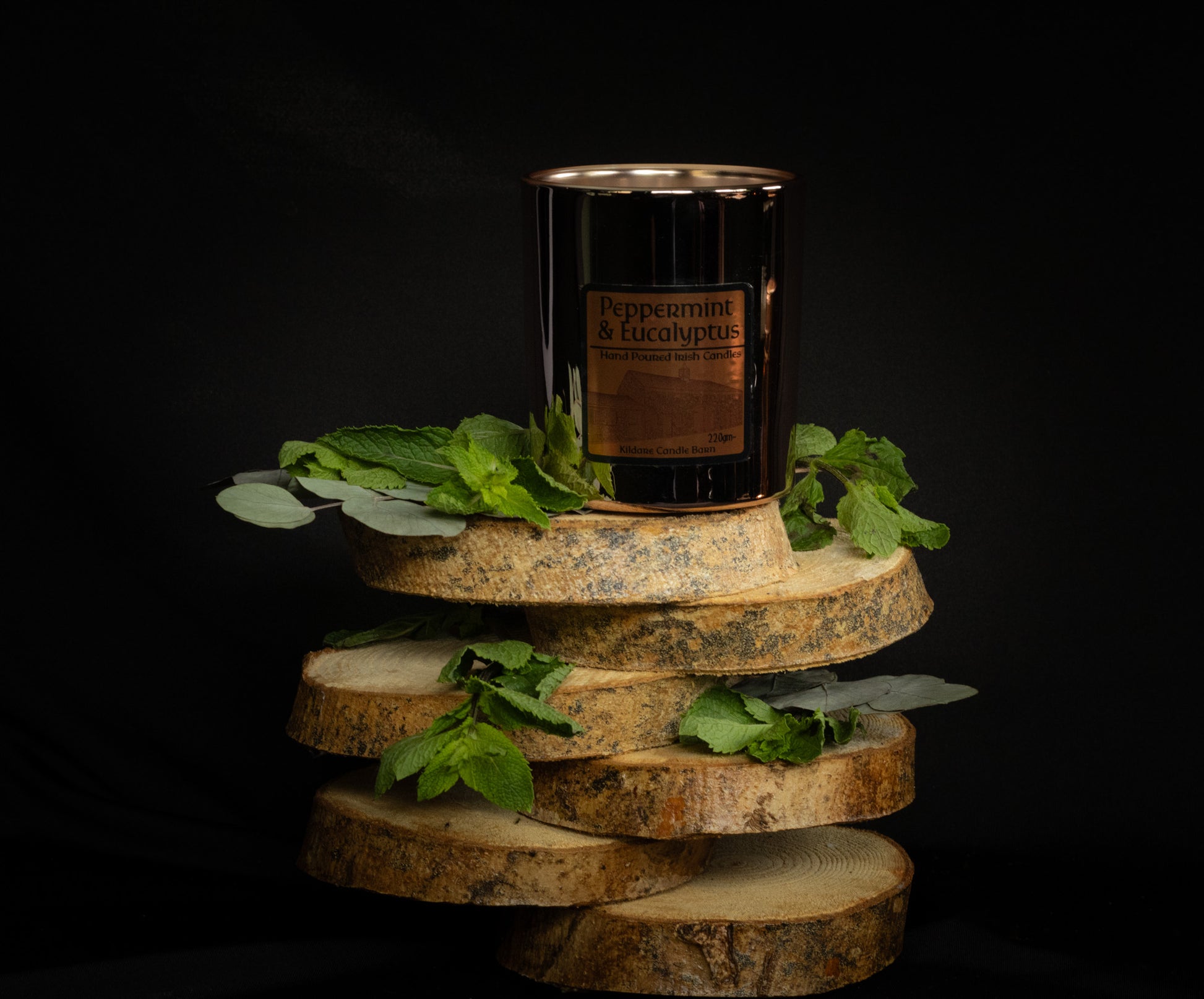 Irish Soy Wax Candle in a Copper Jar with mint and eucalyptus  leaves on a dark background