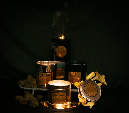 Irish Soy Wax Candles in  tins and jars with 'Irish Turf' branding on a dark background and smoking turf embers.