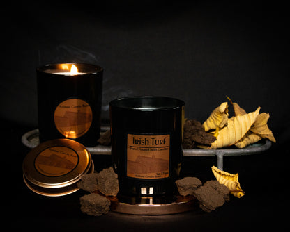Irish Soy Wax Candles in  black  jar with 'Irish Turf' branding on a dark background and smoking turf embers.