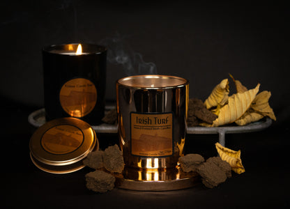 Irish Soy Wax Candles in  copper  jar with 'Irish Turf' branding on a dark background and smoking turf embers.