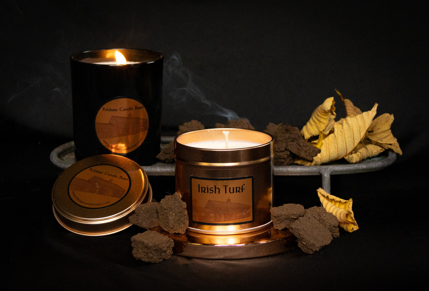 Irish Soy Wax Candles in  copper tin with 'Irish Turf' branding on a dark background and smoking turf embers.