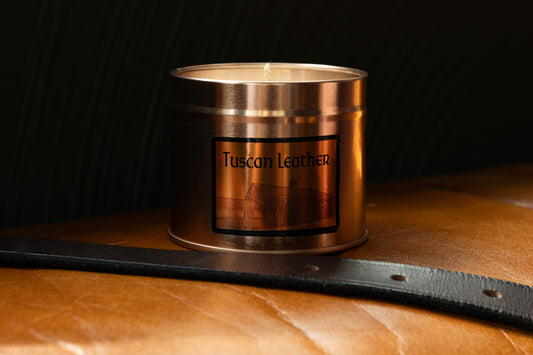 Irish Soy Wax Candle in a Copper container with 'Tuscan Leather' label on a leather surface